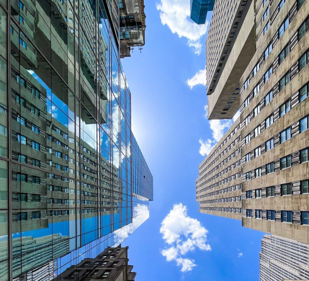 Street view looking straight up at skyscrapers.