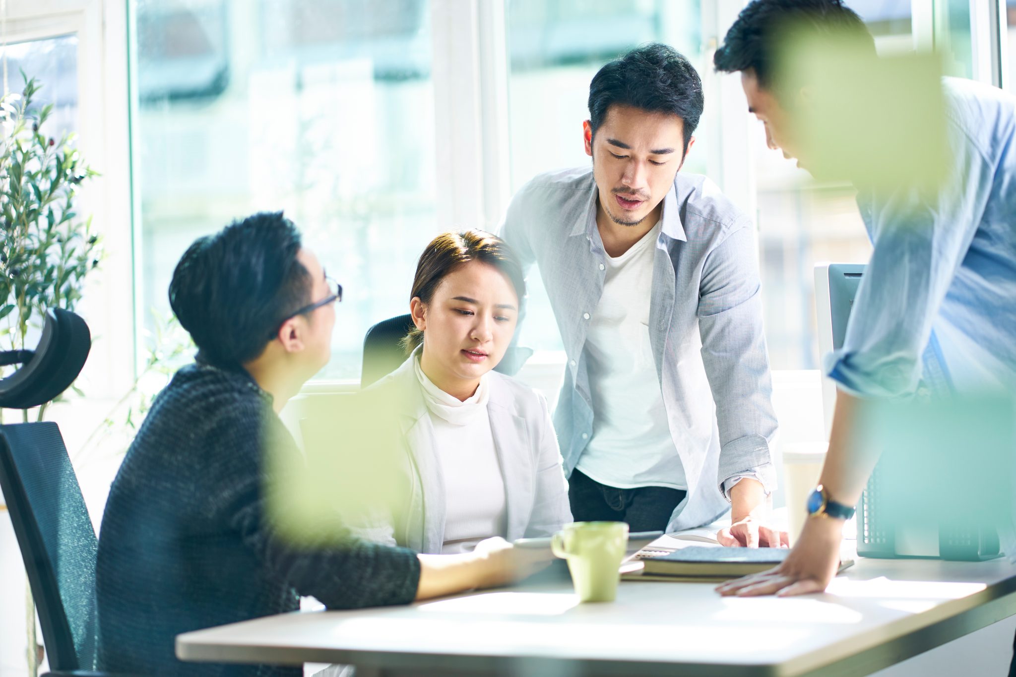 Corporate executives meeting in an office discussing investment strategy.